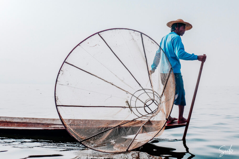 Pêcheur traditionnel avec filet conique sur le lac Inle au Myanmar